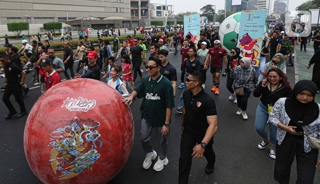 Masryarakat bersama sejumlah artis dan influencer ditambah khalayak umum ikut meramaikan parade bola raksasa dari kawasan Sarinah menuju Bundaran HI, lokasi piala dipamerkan. (Liputan6.com/Faizal Fanani)