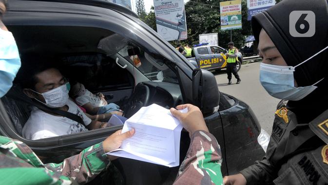 Petugas gabungan Satgas COVID-19 memeriksa surat rapid test antigen pengguna kendaraan di jalur wisata Puncak, Gadog, Bogor, Jawa Barat, Jumat (12/2/2021). Pemeriksaan dan penyekatan sebagai upaya meminimalisir penyebaran COVID-19 saat libur Imlek 2572 dan akhir pekan. (merdeka.com/Arie Basuki)