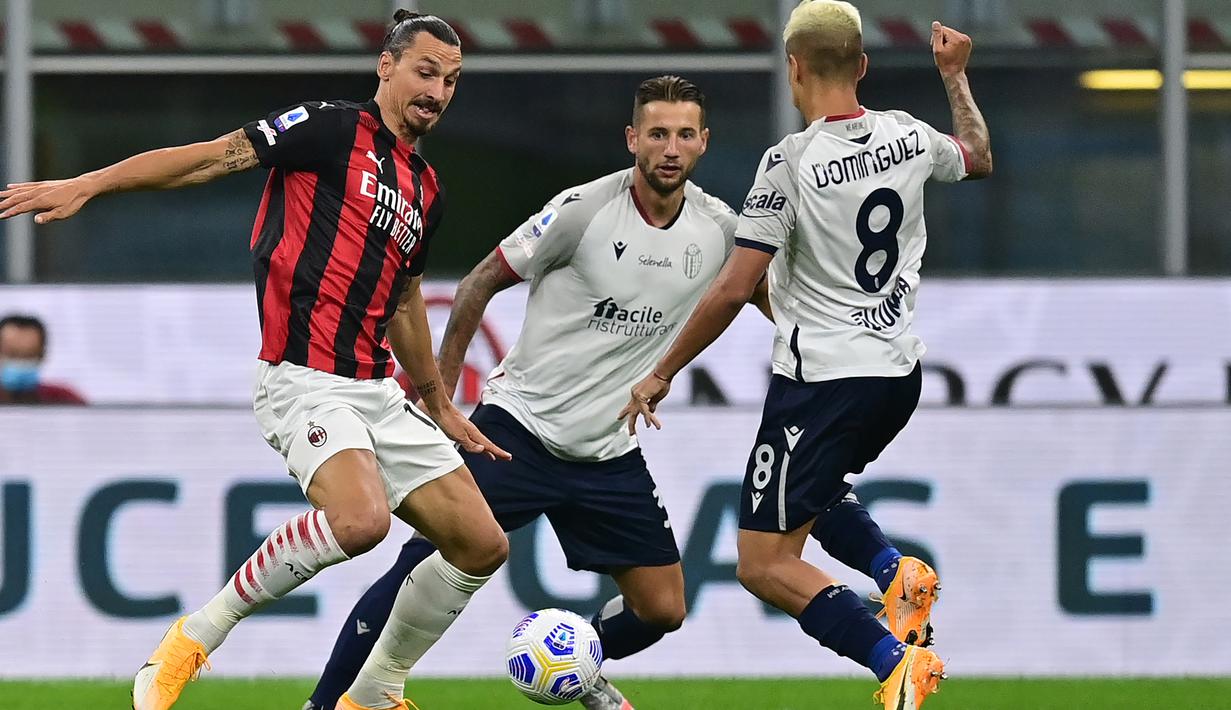 Penyerang AC Milan, Zlatan Ibrahimovic, berusaha melewati pemain Bologna pada laga Liga Italia di Stadion San Siro, Selasa (22/9/2020) dini hari WIB. AC Milan menang 2-0 atas Bologna. (AFP/Miguel Medina)