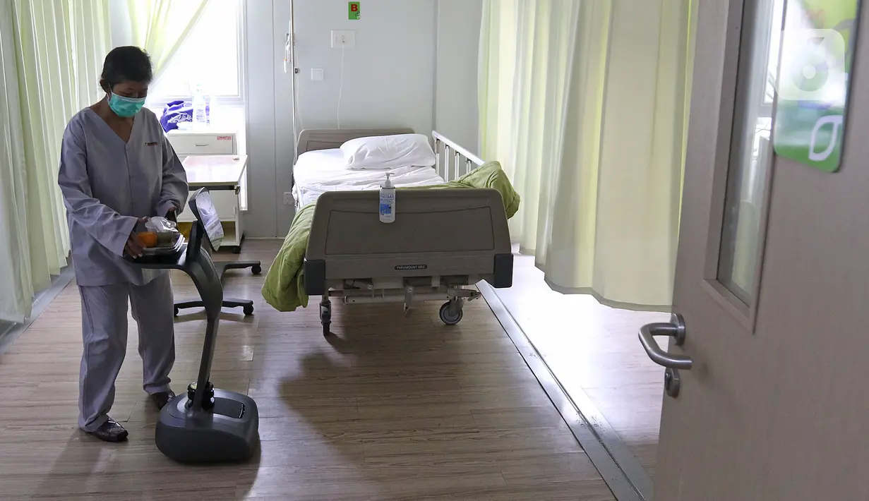 Pasien sedang mengambil makanan di robot temi saat di  kamar pasein  RSPJ Modular, Jakarta, Selasa (28/7/2020). Teknologi robot ini juga dapat mengantarkan makanan dan menghibur para pasien dengan cara mendengarkan lagu dan senam bersama. (Liputan6.com/Herman Zakharia)