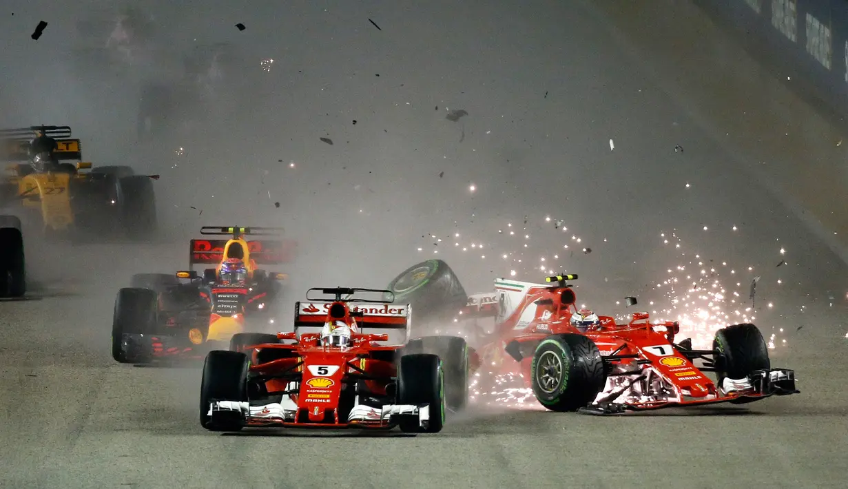 Pembalap Ferrari, Kimi Raikkonen dari Finlandia bertabrakan dengan rekan satu timnya Sebastian Vettel dari Jerman pada awal Grand Prix Singapura Formula One di Sirkuit Marina Bay City, Singapura, Minggu, (17/09) (AP Photo / Yong Teck Lim)