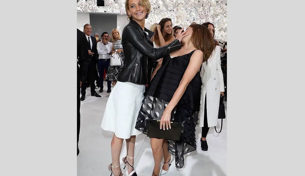 Jennifer Lawrence seolah 'menampar' dan menaruh tangannya di wajah rekan sesama aktris, Emma Watson di Paris, Senin (7/7/14). (Getty Images)