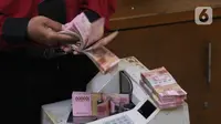 Petugas menghitung uang rupiah di penukaran uang di Jakarta, Senin (9/11/2020). Nilai tukar rupiah terhadap dolar AS bergerak menguat pada perdagangan di awal pekan ini Salah satu sentimen pendorong penguatan rupiah kali ini adalah kemenangan Joe Biden atas Donald Trump. (Liputan6.com/Angga Yuniar)