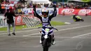 Fitriansyah Kete mengangkat tangan usai memastikan tampil tercepat diputaran kedua IP 110 cc seri 1 Indoprix 2014 yang digelar di SIKC, Bogor, (27/4/2014). (Liputan6.com/Helmi Fithriansyah)