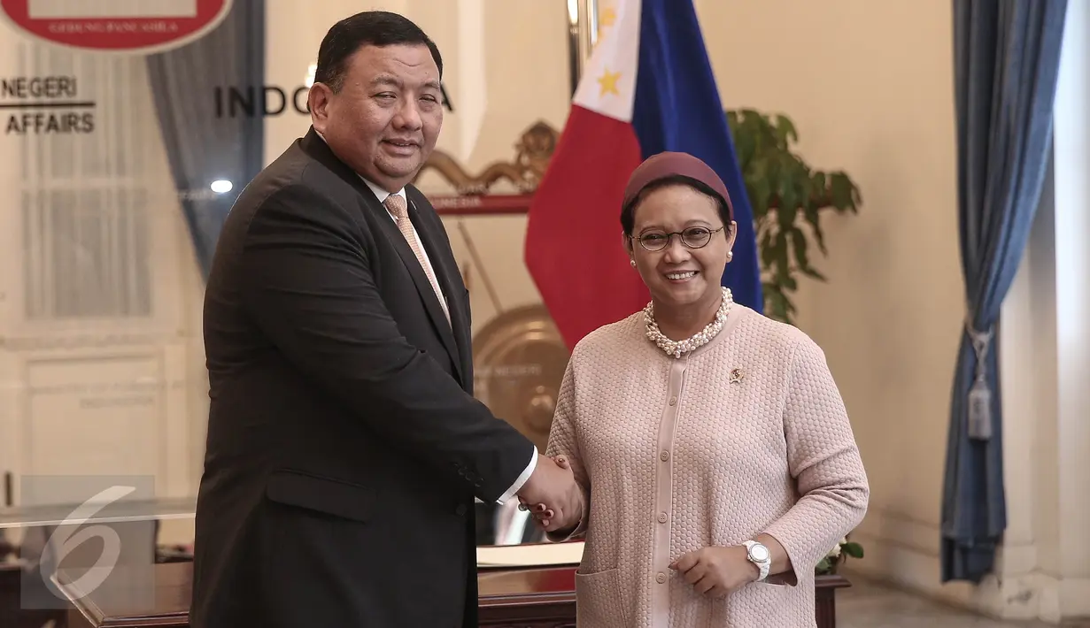 Menlu RI Retno Marsudi dan Menlu Filipina Jose Rene D. Almendras berjabat tangan saat kunjungan kerja di Kemenlu, Jakarta, Rabu (4/5). Pertemuan tertutup itu terkait pembahasan 4 WNI yang masih disandera kelompok Abu Sayyaf. (Liputan6.com/Faizal Fanani)