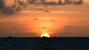 Perahu nelayan difoto saat matahari terbit di lepas pantai pulau Phu Quoc selatan Vietnam (19/11/2021). Mulai 20 November, penerbangan charter untuk pelancong internasional dengan paspor vaksin akan disambut di pulau itu. (AFP/Nhac Nguyen)