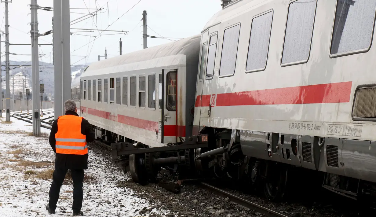 Seorang petugas regu penyelamat berdiri di lokasi tabrakan yang melibatkan dua kereta penumpang dekat stasiun di Niklasdorf, Austria, Senin (12/2). Sejauh ini 17 orang harus mendapatkan perawatan medis akibat luka serius yang diderita. (AP/Ronald Zak)