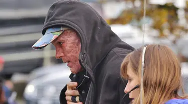 Aktor Hollywood Ryan Reynolds berjalan dengan menutupi wajahnya yang tertutup make up seperti luka terbakar untuk melakukan syuting  "Deadpool". Aktor 39 tahun ini memerankan wajah Wade Wilson dalam filmnya tersebut. (Dailymail)