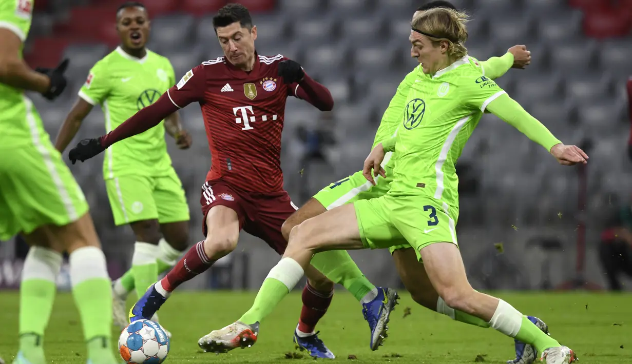 Bek VfL Wolfsburg Sebastiaan Bornauw (kanan) berebut bola dengan penyerang Bayern Munchen Robert Lewandowski pada pekan ke-17 Liga Jerman di Allianz Arena Sabtu (18/12/2021) dinihari WIB. Bayern mencukur Wolfsburg dengan skor 4-0. (AP Photo/Andreas Schaad)
