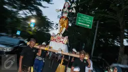 Umat Hindu mengarak Ogoh-ogoh di Jalan Tanah Abang, Jakarta, Senin (27/3). Pawai ogoh-ogoh tersebut bertujuan untuk mengusir energi negatif di alam semesta. (Liputan6.com/Gempur M. Surya)