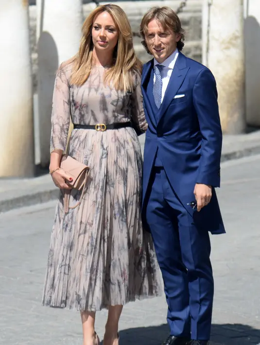 Pemain tengah Real Madrid Luka Modric dan istrinya Vanja Bosnic berpose saat tiba di gereja menghadiri upacara pernikahan bek Sergio Ramos dan Pilar Rubio di Katedral Seville, Spanyol (15/6/2019). (AFP Photo/Cristina Quicler)