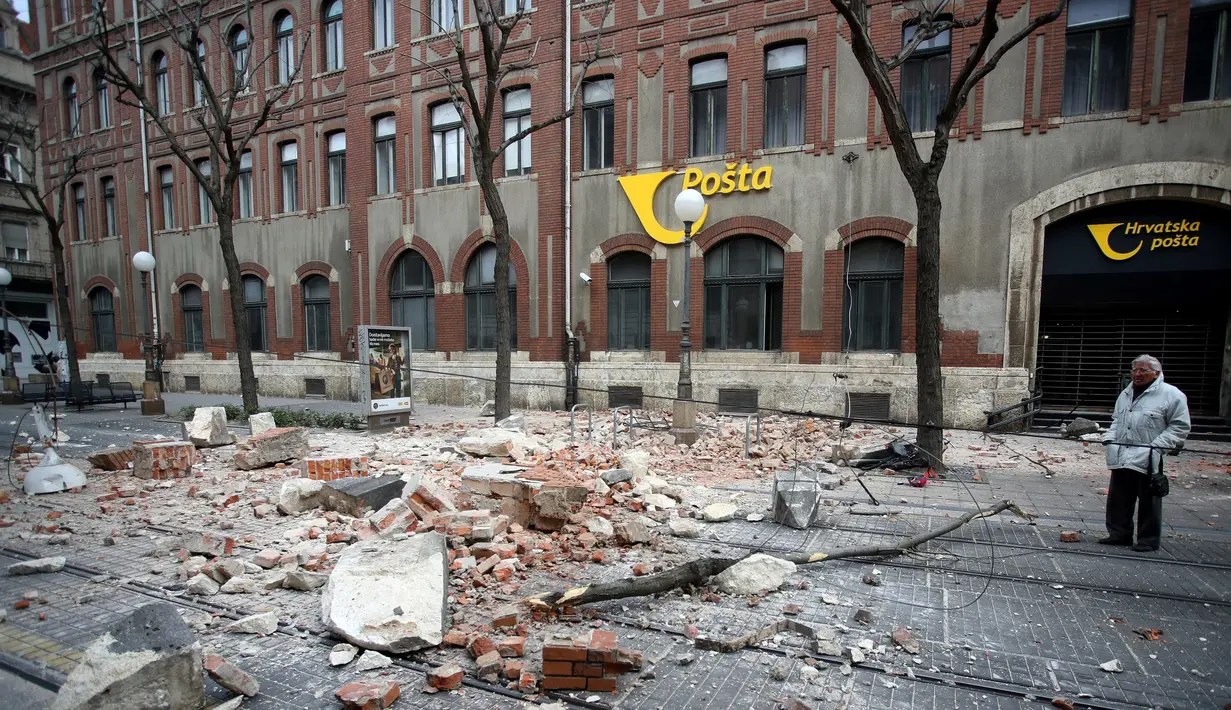 Seorang warga berjalan di dekat reruntuhan bangunan akibat gempa magnitudo 5,3 di pusat kota Zagreb, Korasia (22/3/2020). (AFP/Damir Sencar)
