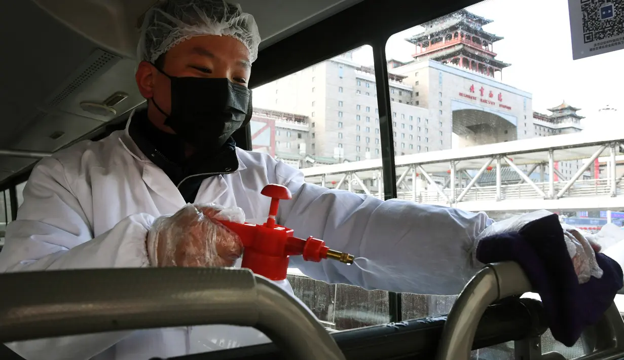 Staf menyemprotkan cairan disinfektan pada pegangan bus di sebuah terminal bus di ibu kota China, 3 Februari 2020. Beijing Public Transport Corporation melakukan pengukuran suhu tubuh karyawan dan memastikan mereka bekerja dengan masker untuk mencegah penyebaran virus corona. (Xinhua/Ren Chao)