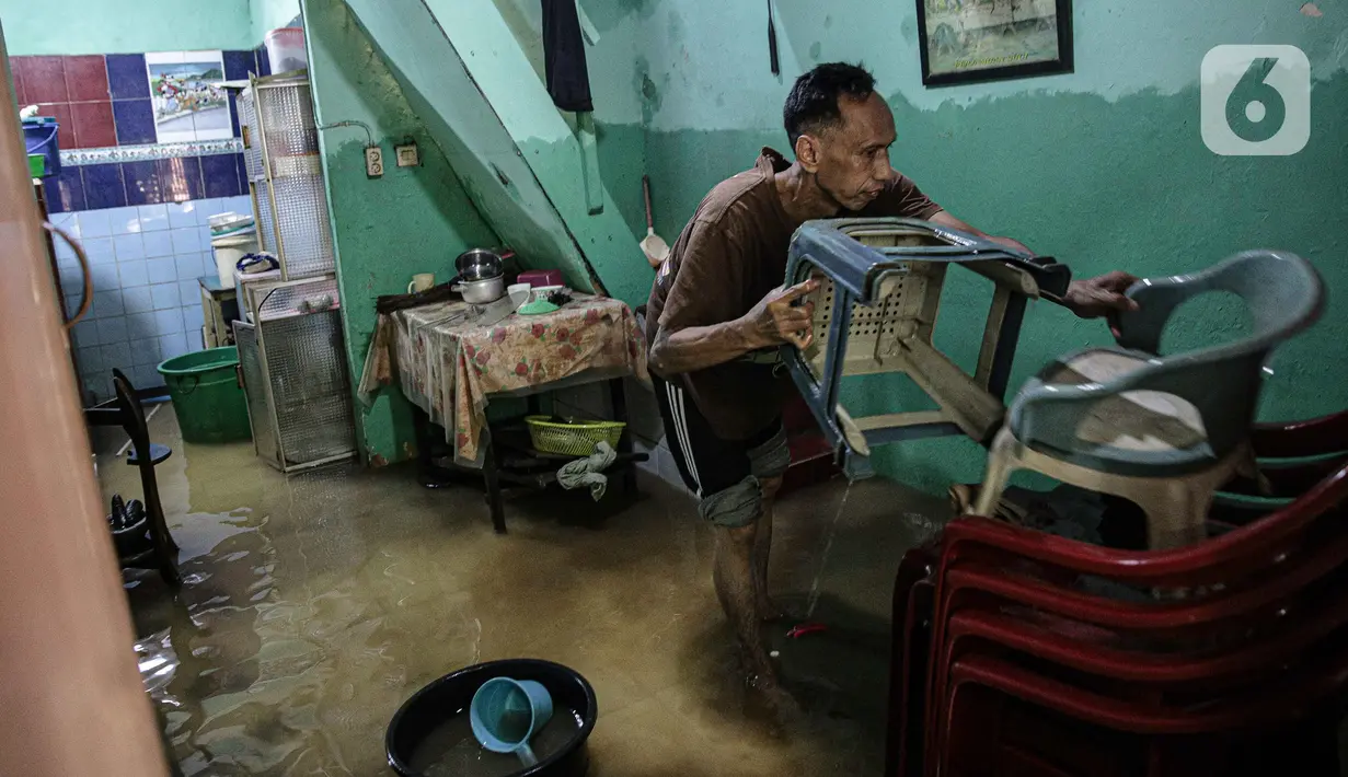 Warga bersih-bersih rumah usai terendam banjir di kawasan Kampung Melayu, Jakarta, Senin (8/11/2021). Warga belum mengungsi dan masih berharap air akan surut. (Liputan6.com/Faizal Fanani)