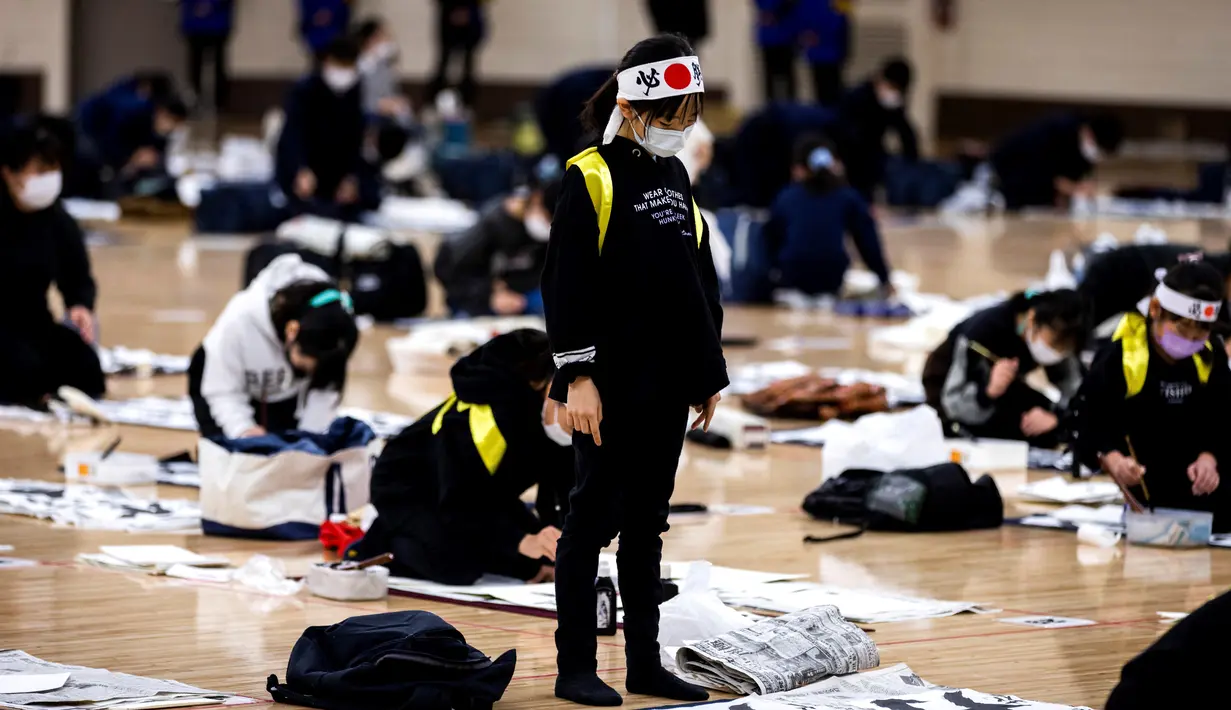 Seorang peserta melihat kaligrafi Jepangnya selama kontes kaligrafi Tahun Baru tahunan di Tokyo (5/1/2022). Lebih dari 3.000 kaligrafer, yang telah memenuhi syarat dalam kompetisi tingkat nasional di seluruh Jepang, ikut serta dalam kontes tahunan untuk merayakan tahun baru. (AFP/Behrouz Mehri)