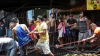 Sejumlah warga mencoba mengambil sisa kabel listrik saat insiden kebakaran sebuah pemukiman padat penduduk dekat pelabuhan di Manila, Filipina, Selasa (9/5). Mereka berebut mengumpulkan tembaga dari sisa kabel listrik. (TED ALJIBE/AFP)