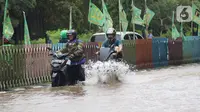 Sejumlah pengendara nekat menerobos genangan banjir di Jalan dr Sutomo, Pasar Baru, Jakarta, Selasa (25/2/2020). Hujan yang mengguyur Jakarta sejak Senin (24/2) malam membuat sejumlah kali meluap dan menyebabkan banjir. (Liputan6.com/Helmi Fithriansyah)