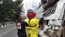 Pemilik tengah memperbaiki ondel-ondel untuk disewakan di kawasan Senen, Jakarta, Jumat (20/9/2024). (Liputan6.com/Angga Yuniar)