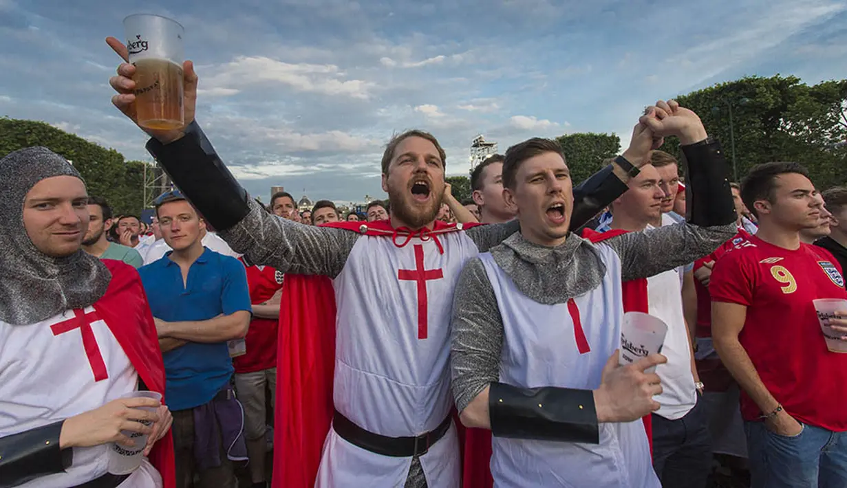 Menggunakan baju tradisional Inggris suporter menyaksikan laga Grup B Piala Eropa 2016 antara Inggris melawan Rusia di fan zone sekitar Menara Eiffel, Prancis, Sabtu (11/6/2016). (AFP/Geoffroy Van Der Hasselt)