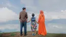 Laudya Cynthia Bella menggenggam tangan putri Engku Emran, Engku Aleesya saat foto prewedding di Sumatera Barat. Dengan bergaun oranye, Laudya Cynthia Bella tampak berfoto dengan latar belakang langit Sumetera Barat yang jernih. (instagram/iamkumbre)