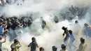 Demonstran menyerang polisi dengan bom asap dan granat gas air mata di depan gedung Parlemen Ukraina , Senin (31/8). Satu petugas tewas dan 90 lainnya terluka dalam aksi yang menentang perubahan UU dasar mengenai desentralisasi. (AFP PHOTO/Genya SAVILOV)