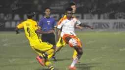 Pemain Gresik United berusaha menghentikan pergerakan pemain Perseru Serui dalam laga Torabika Soccer Championship presented by IM3 Ooredoo di Stadion Tridarma, Gresik, Sabtu (7/5/2016). (Bola.com/Fahrizal Arnas)