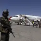 Seorang tentara Taliban berjaga-jaga ketika penumpang turun dari Kandahar, di Bandara Internasional Hamid Karzai di Kabul, Afghanistan, Minggu (5/9/2021). Bandara tersebut kembali dibuka untuk penerbangan domestik. (AP/Wali Sabawoon)