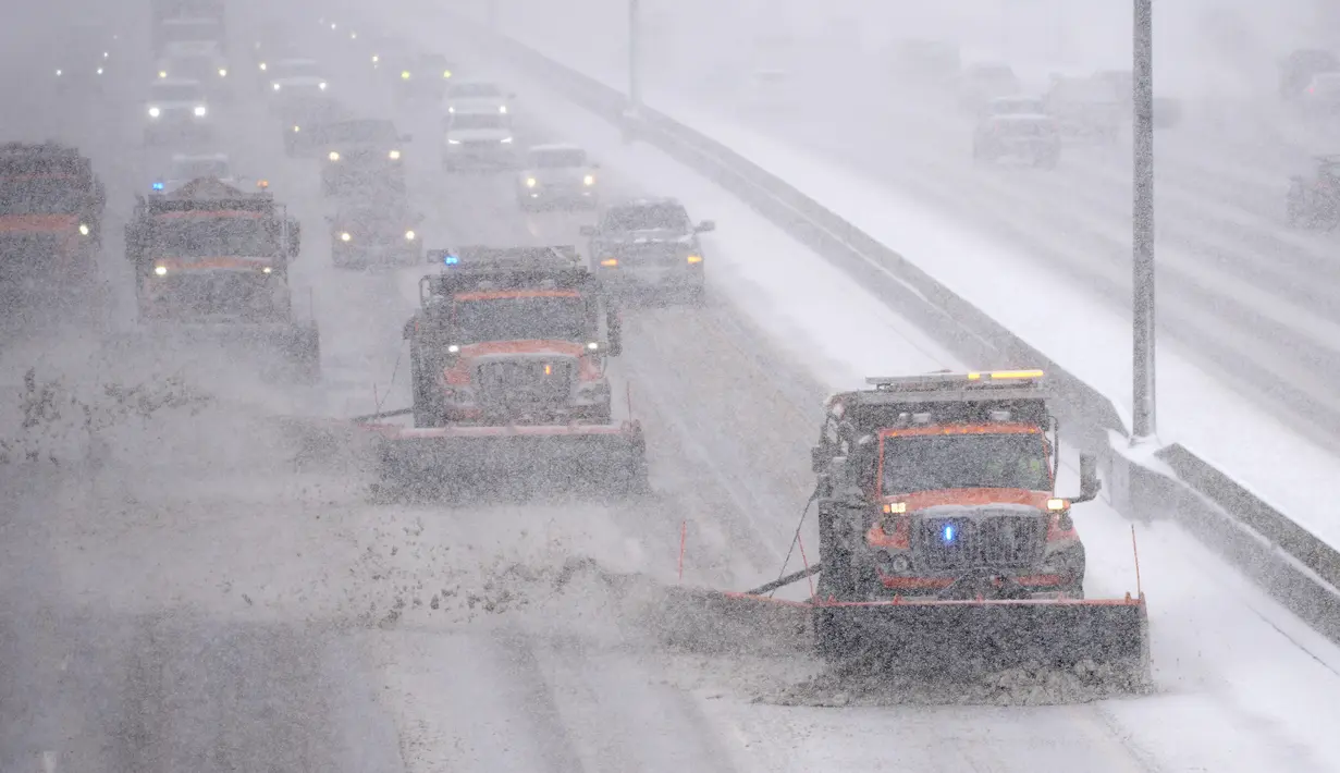 Pengemudi mengikuti kuartet bajak salju Negara Bagian Colorado di Interstate 25 di jalan layang Steele Street saat badai musim dingin yang membawa angin kencang dan salju lebat bergerak melintasi intermountain West di Denver (27/1/2022). (AP Photo/David Zalubowski)