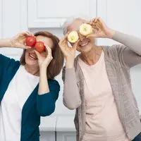 Dua orang perempuan sedang memegang buah di depan matanya (Foto Dok: Freepik/freepik).