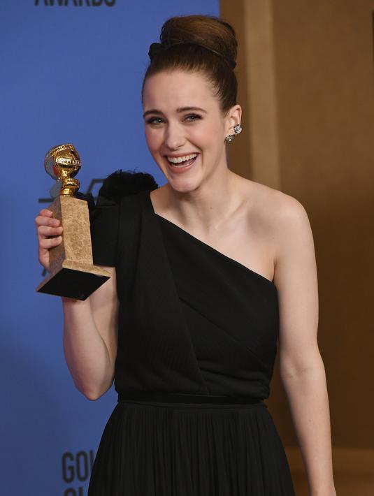 Rachel Brosnahan tertawa saat berpose dengan penghargaan Aktris Terbaik dalam Serial televisi, Komedi atau Musikal untuk serial "The Marvelous Mrs. Maisel" di Golden Globe Awards 2018 di Beverly Hills, California (7/1). (Kevin Winter/Getty Images/AFP)