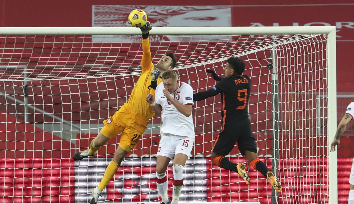 Kiper Polandia, Lukasz Fabianski berusaha meninju bola saat bertanding melawan Belanda pada pertandingan UEFA Nations League di Silesian Stadium, Polandia, Rabu (18/11/2020). Belanda menang 2-1 atas Polandia. (AP Photo/Czarek Sokolowski)