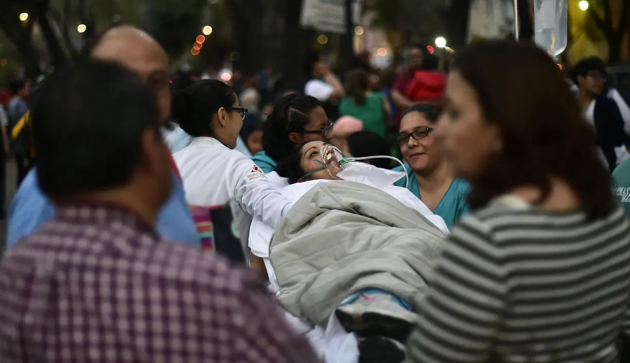 Seorang pasien dievakuasi dari sebuah rumah sakit saat terjadi gempa kuat di Mexico City, Meksiko (16/2). Gempa bumi berkekuatan 7,2 Skala Richter (SR) mengguncang Meksiko. (AFP Photo/Pedro Pardo)