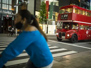 Sebuah bus bertingkat yang digunakan untuk iklan melintasi kota menunggu di lampu lalu lintas di distrik perbelanjaan Ginza Tokyo, Kamis (23/9/2021). Kawasan ini dikenal sebagai kawasan mewah di Tokyo. (AP Photo/Hiro Komae)