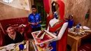 Seorang pelayan robot bernama Ruby menyajikan makanan kepada pelanggan di restoran Drink and Spice Magic, Dubai, 26 Juli 2018. Robot putih biru yang dipercantik dengan syal merah itu mengantar makanan dengan nampan yang mereka bawa. (AFP/GIUSEPPE CACACE)
