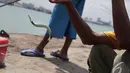 Seorang pemancing sedang berusaha melepaskan ikan hasil tangkapanya di kawasan Pelabuhan Muara Baru, Jakarta, Minggu (11/1/2015). (Liputan6.com/Faizal Fanani)