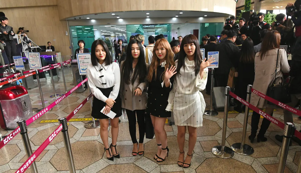 Anggota girlband K-pop "Red Velvet" berpose untuk difoto sebelum berangkat ke Pyongyang dari Bandara Internasional Gimpo di Seoul (31/1). Di dalam rombongan, ikut serta pula Cho Yong-pil, 68, yang dijuluki "Raja K-Pop". (Jung Yeon-je / AFP)