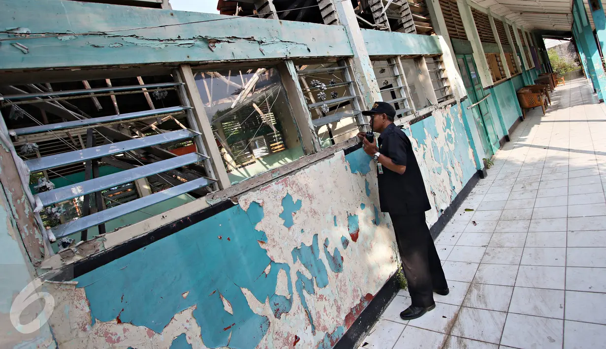 Petugas keamanan saat mengecek ruang kelas yang rusak di SDN Klender 15, Jakarta Timur, Rabu (18/11). 293 siswa SDN Klender 15 terpaksa mengungsi belajar di SDN Klender 14. (Liputan6.com/Immanuel Antonius)