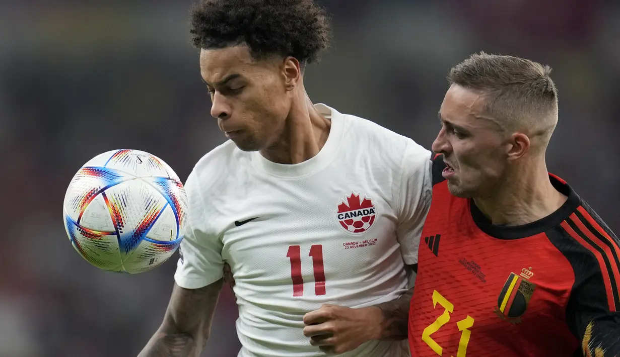 Penyerang Kanada, Tajon Buchanan berebut bola dengan pemain Belgia, Timothy Castagne pada pertandingan grup F Piala Dunia 2022 Qatar di Stadion Ahmad Bin Ali di Doha, Qatar, Kamis (24/11/2022). Belgia menang tipis atas Kanada 1-0.  (AP Photo/Natacha Pisarenko)