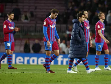 Para pemain tim Barcelona berjalan setelah pertandingan melawan Rayo Vallecano pada lanjutan La Liga Spanyol di stadion Camp Nou di Barcelona, Spanyol, Senin (25/4/2022). Barcelona tumbang atas Rayo Vallecano 0-1. (AP Photo/Joan Monfort)