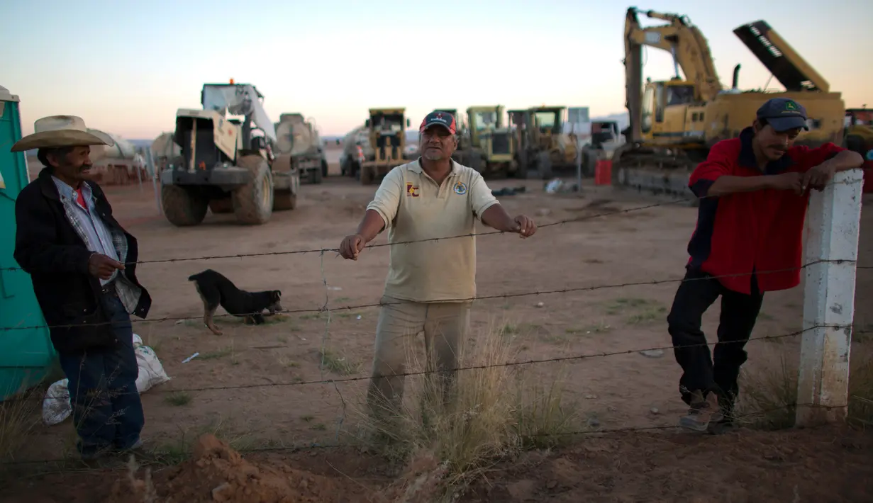 Sejumlah petugas berjaga di dekat alat berat yang tersisa di lokasi pembangunan pabrik Ford di di Villa de Reyes, San Luis Potosi, Meksiko, (4/1). (AP Photo/Rebecca Blackwell)