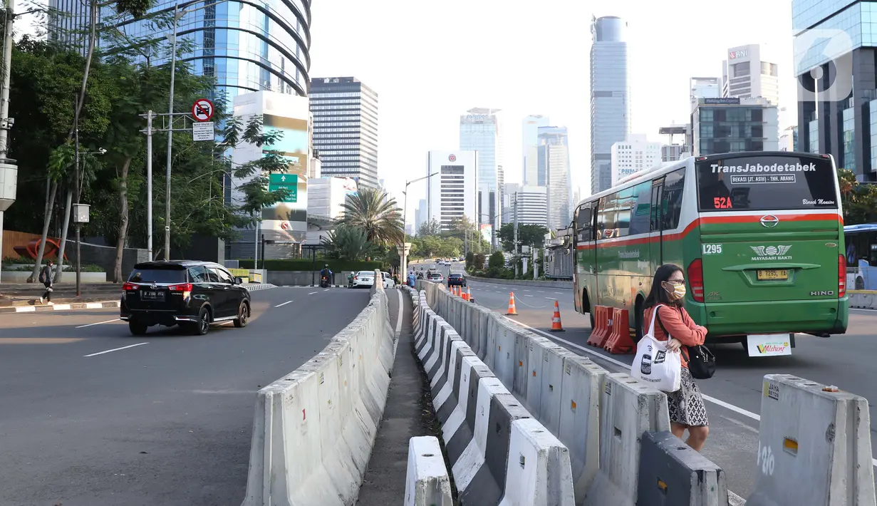 Pejalan kaki menanti angkutan umum di Jalan Jenderal Sudirman, Jakarta, Rabu (23//9/2020). Menteri Keuangan Sri Mulyani Indrawati memastikan ekonomi nasional resesi pada kuartal III-2020. Kondisi ini akan berdampak pada pelemahan daya beli masyarakat hingga PHK. (Liputan6.com/Helmi Fithriansyah)