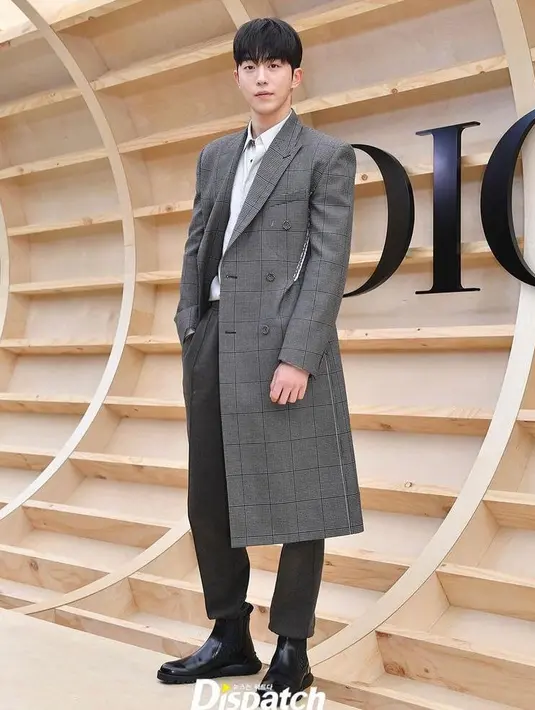 <p>Tak ketinggalan, lawan main Suzy di Startup, Nam Joo Hyuk  tampil di depan Kamera mengenakan  long coat warna abu-abu, kemeja putih, dan celana panjang warna cokelat. (Instagram/koreadispatch).</p>
