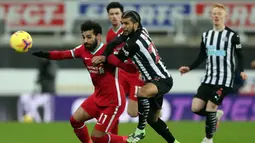 Gelandang Liverpool, Mohamed Salah (kiri) berebut bola dengan bek Newcastle United, DeAndre Yedlin dalam laga lanjutan Liga Inggris 2020/21 pekan ke-16 di St James' Park, Rabu (30/12/2020). Liverpool bermain imbang 0-0 dengan Newcastle United. (AFP/Scott Heppell/Pool)