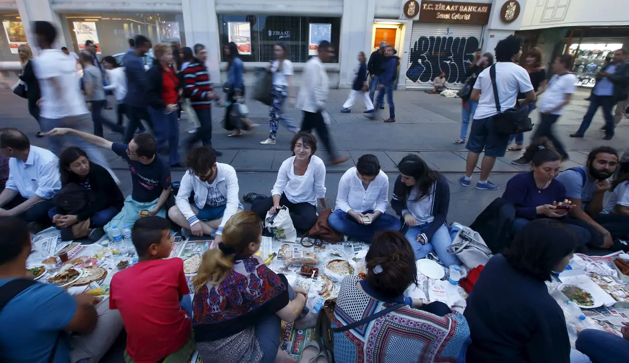 Sejumlah orang sedang menunggu waktu berbuka puasa pada hari pertama bulan suci Ramadan, di Taksim Square, Istanbul, Turki, Kamis (18/6/2015). Tradisi buka puasa beramai-ramai sudah menjadi tradisi di negara tersebut. (REUTERS/Osman Orsal)