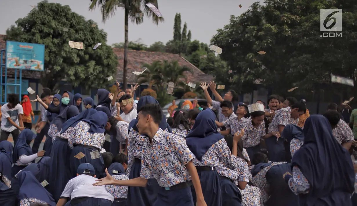 Para murid saling berebut hujan uang di lapangan SMP Angkasa Halim Perdana Kusuma, Jakarta, Kamis (7/6). Hujan uang ini dalam rangka pre-launching buku milik motivator bisnis Tung Desem Waringin berjudul "LIFE REVOLUTION." (Liputan6.com/Faizal Fanani)