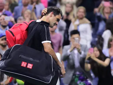 Petenis Roger Federer tertunduk saat berjalan keluar lapangan usai kalah dari Grigor Dimitrov pada perempat final turnamen tenis AS Terbuka 2019 di New York, Amerika Serikat, Selasa (3/9/2019). Dimitrov menang 3-6, 6-4, 6-3, 6-4, 6-2. (AP Photo/Charles Krupa)
