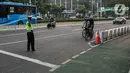 Polisi menghalau pesepeda yang berada di luar jalur di kawasan Sudirman-Thamrin, Jakarta Pusat, Rabu (2/6/2021). Wakil Gubernur DKI Jakarta Ahmad Riza Patria mengatakan, sepeda road bike diperbolehkan untuk melintas di Jalan Sudirman-Thamrin pada hari kerja Senin-Jumat. (Liputan6.com/Faizal Fanani)