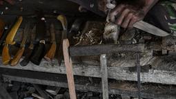 Seorang pandai besi menunjukkan belati tradisional Aceh yang dikenal sebagai 'rencong' di sebuah bengkel di Sibreh, provinsi Aceh (5/10/2021). Ada beberapa jenis rencong. Pertama Rencong Pudoi yaitu Rencong yang belum sempurna pada bentuk gagangnya. (AFP/Chaideer Mahyuddin)