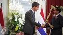 Perdana Menteri Kerajaan Belanda Mark Rutte (kiri) memberikan cindramata sebuah keris kepada Presiden Joko Widodo seusai memberikan pernyataan bersama di Istana Merdeka, Jakarta, Rabu (23/11). (Liputan6.com/Faizal Fanani)