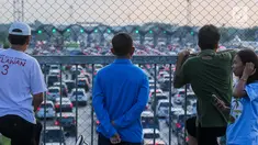 Warga melihat kemacetan arus lalu lintas di Gerbang Tol Utama Palimanan, Cirebon, Jawa Barat, Kamis (29/6). Menjelang sore hari warga berwisata sambil menyaksikan kemacetan volume kendaraan saat arus balik menuju Jakarta. (Liputan6.com/Faizal Fanani)